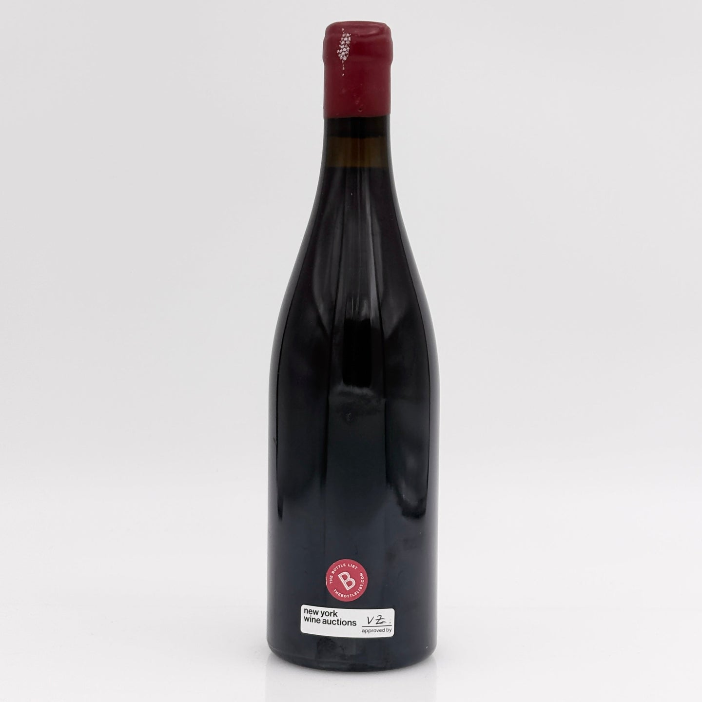 Red wine bottle with a visible label on a white background