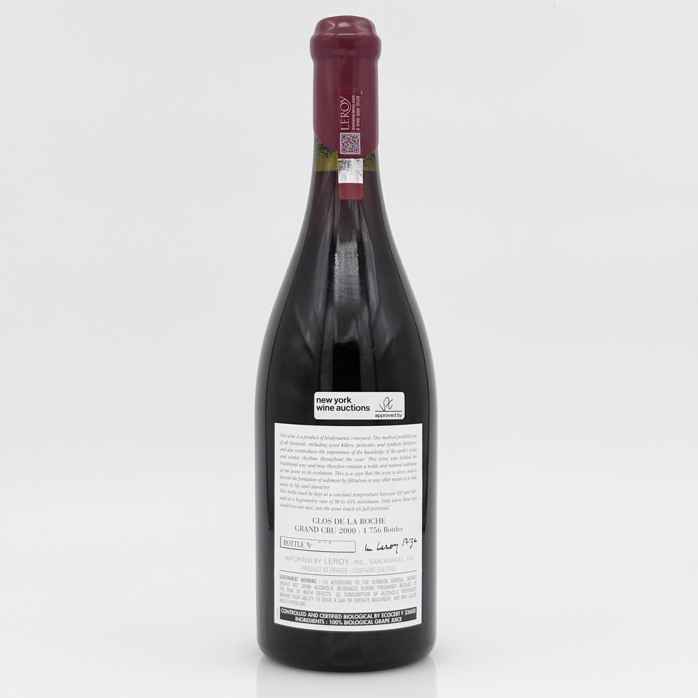 Red wine bottle with a visible label on a white background