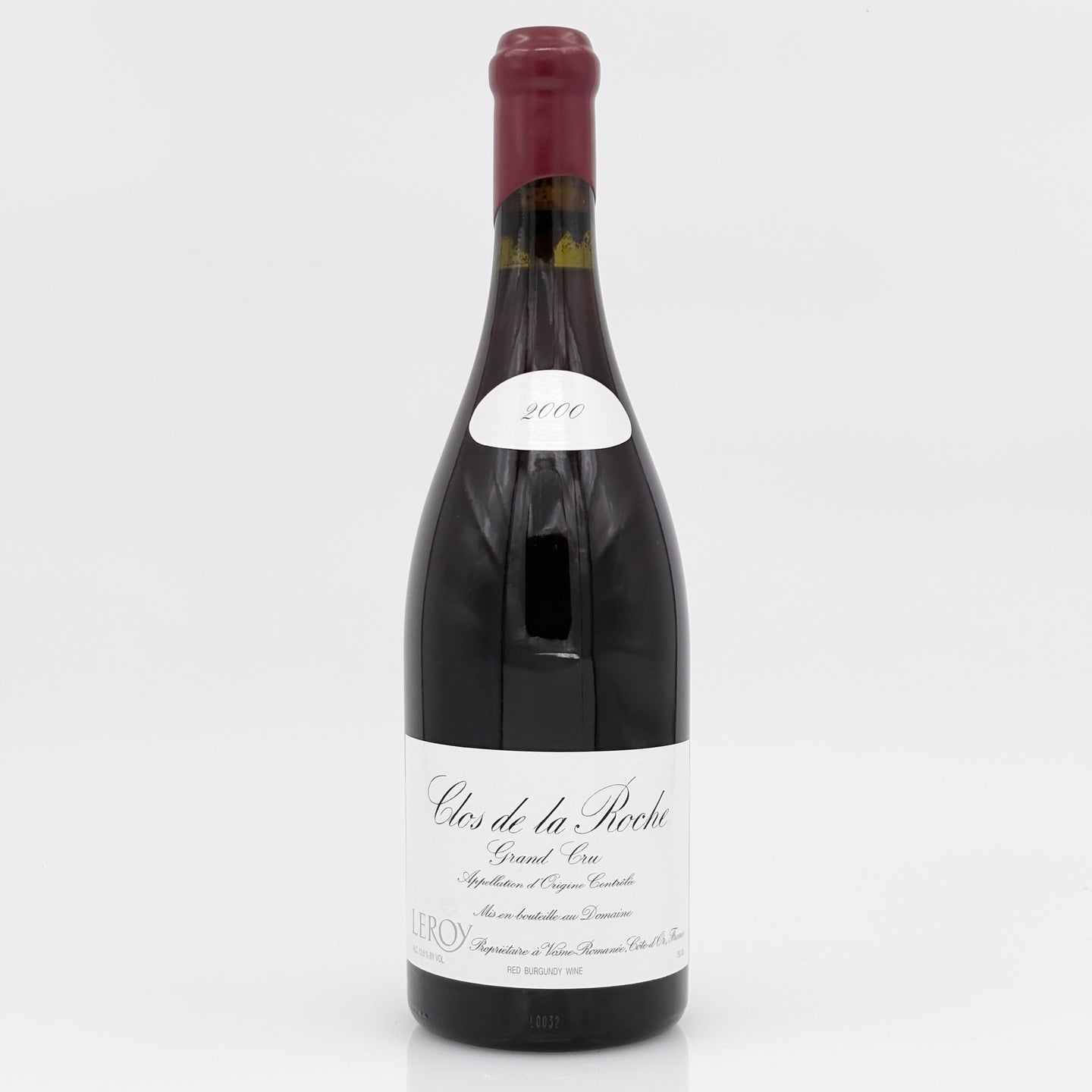 Red wine bottle with a white label on a light gray background