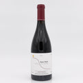 Red wine bottle with a white label on a light gray background
