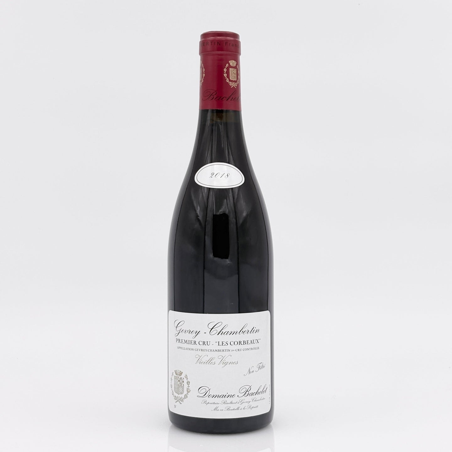 Red wine bottle with a white label on a light gray background
