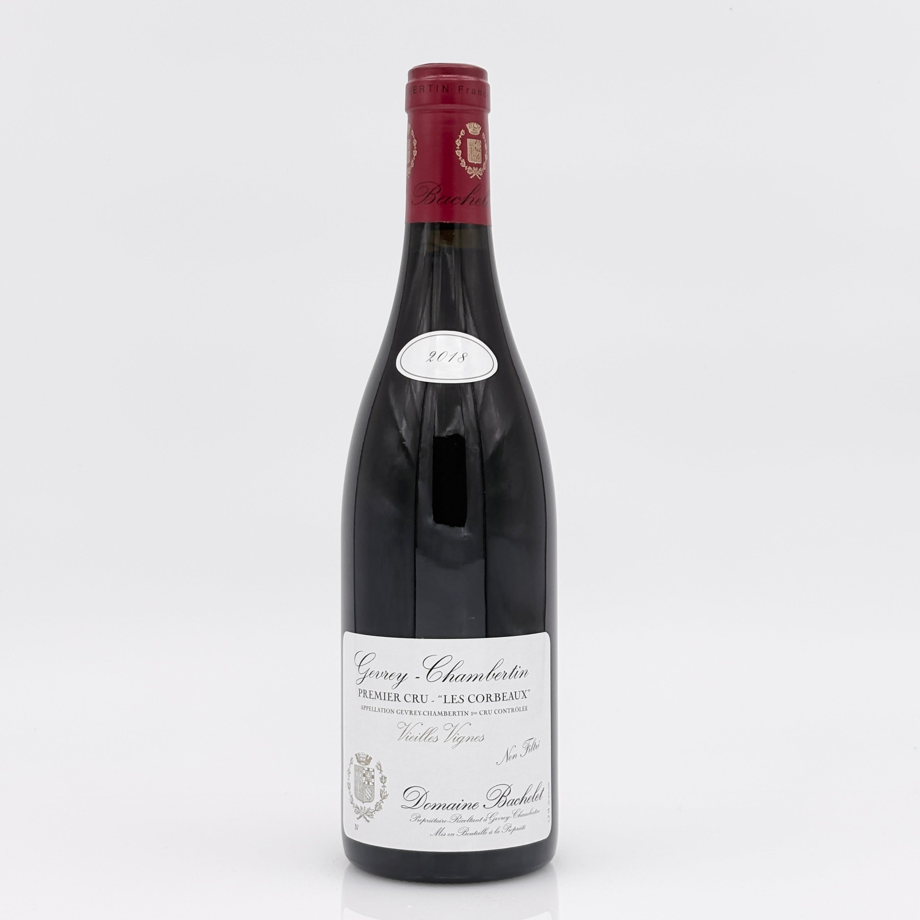 Red wine bottle with a white label on a light gray background