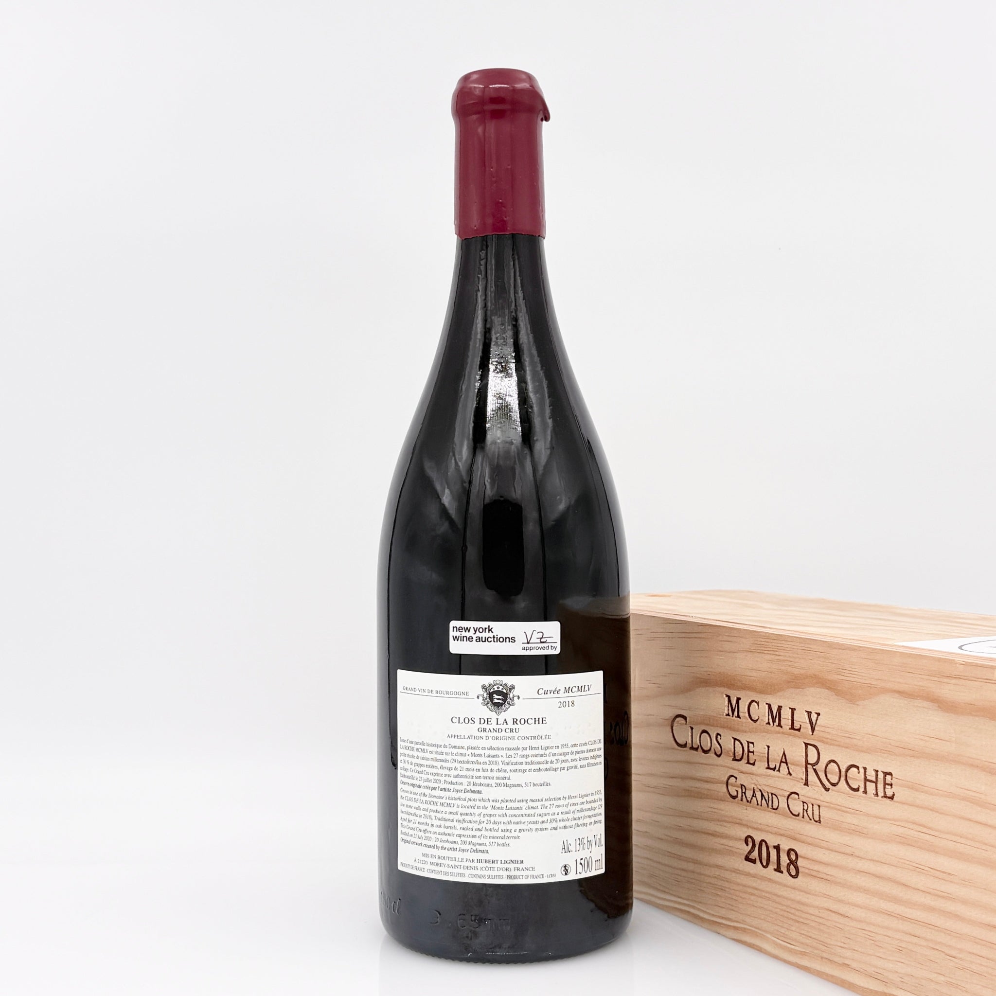Wine bottle with wooden box labeled 'Clos de la Roche' on a white background