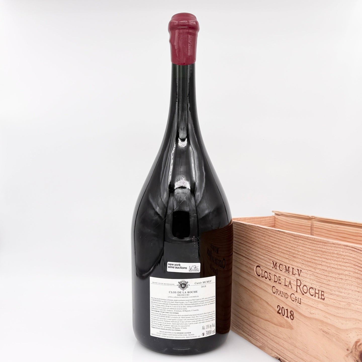 Red wine bottle with a wooden box on a white background