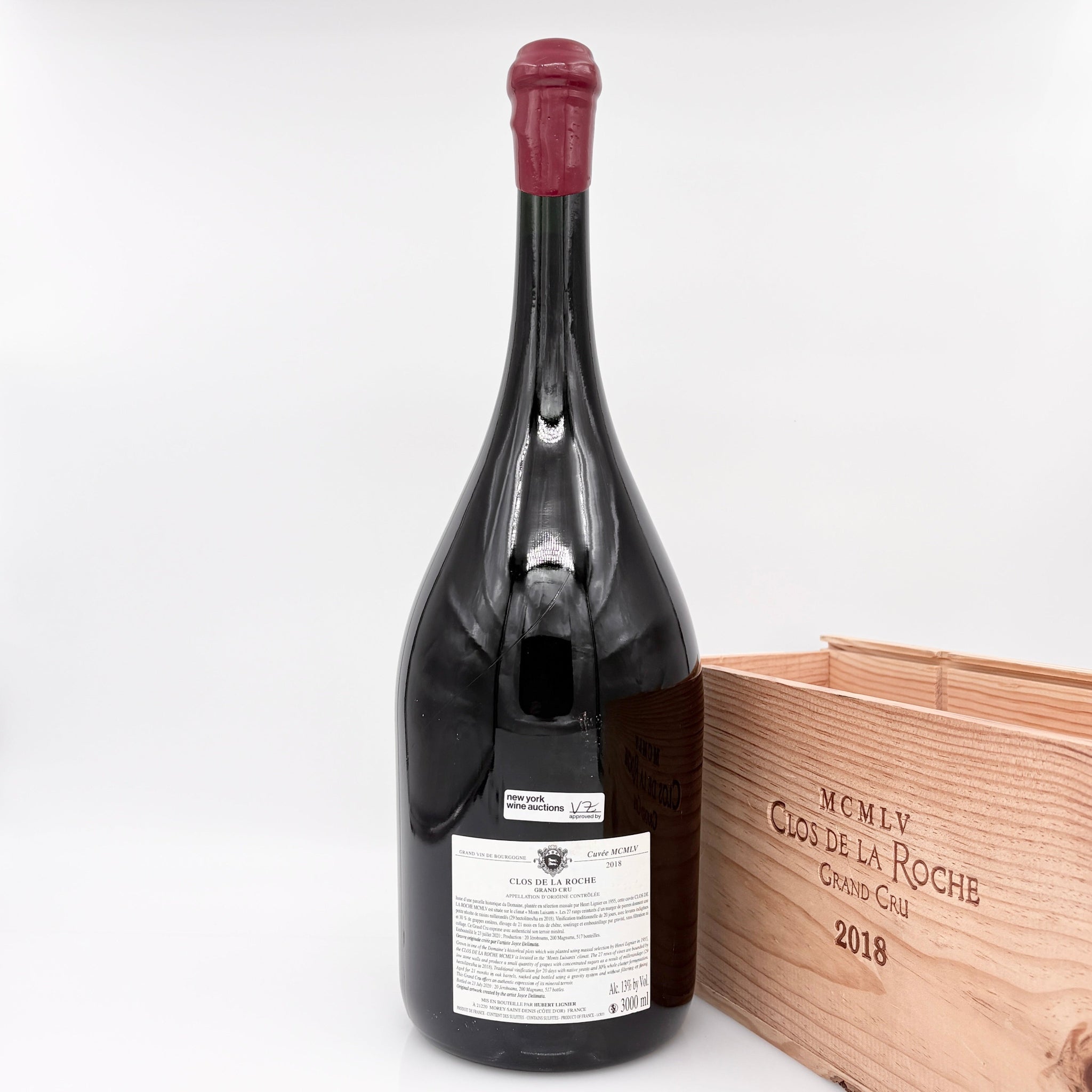 Red wine bottle with a wooden box on a white background