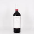 Red wine bottle with a white label on a light gray background