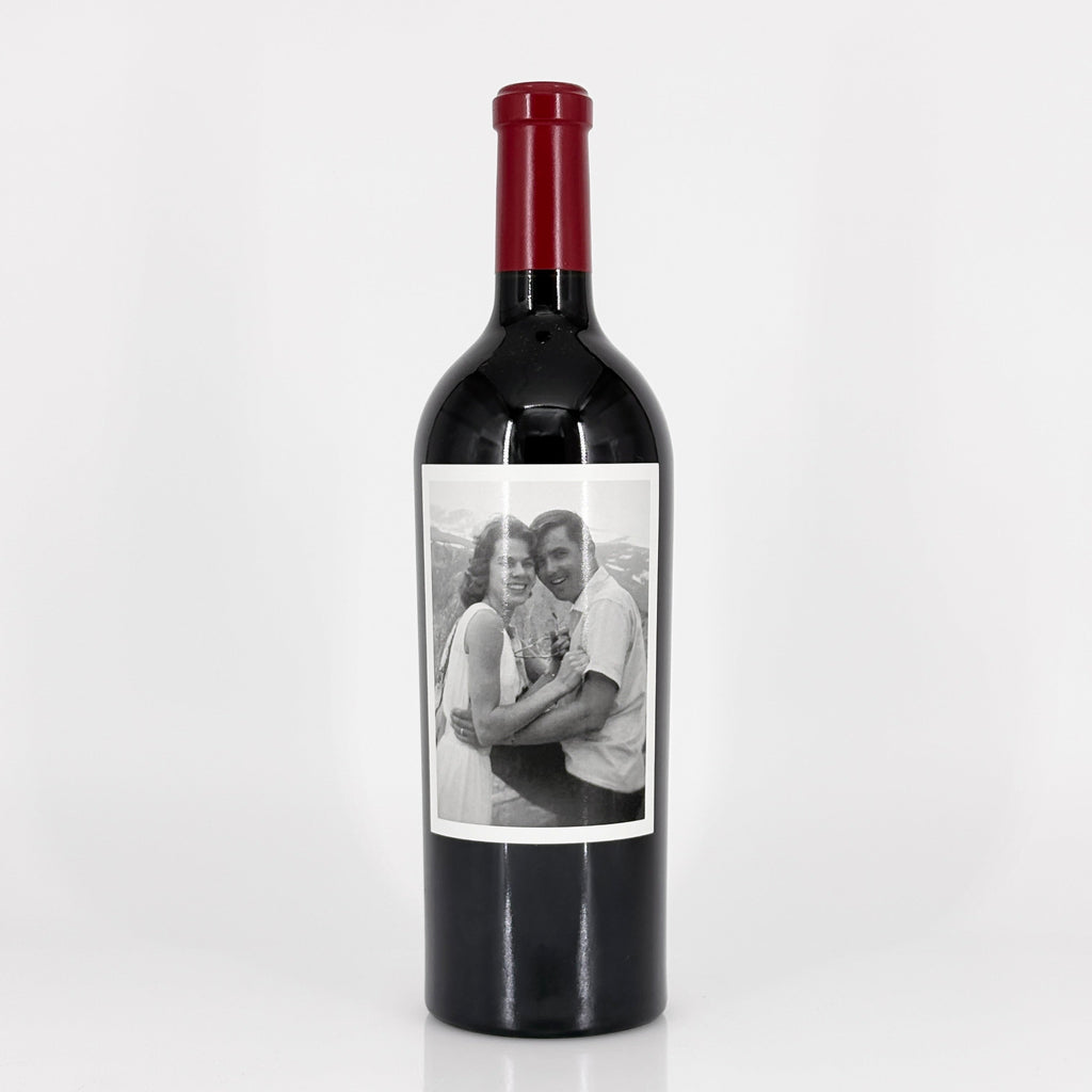 Wine bottle with a label featuring a black and white photo of a couple on a white background