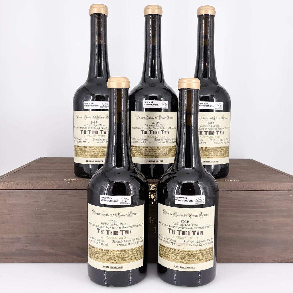 Five bottles of  wine in a wooden box on a white background