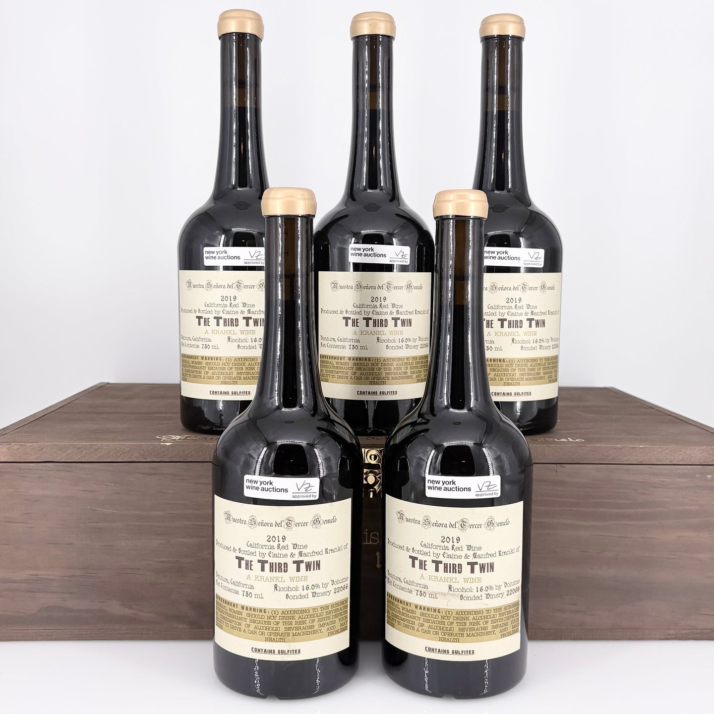 Five bottles of  wine in a wooden box on a white background