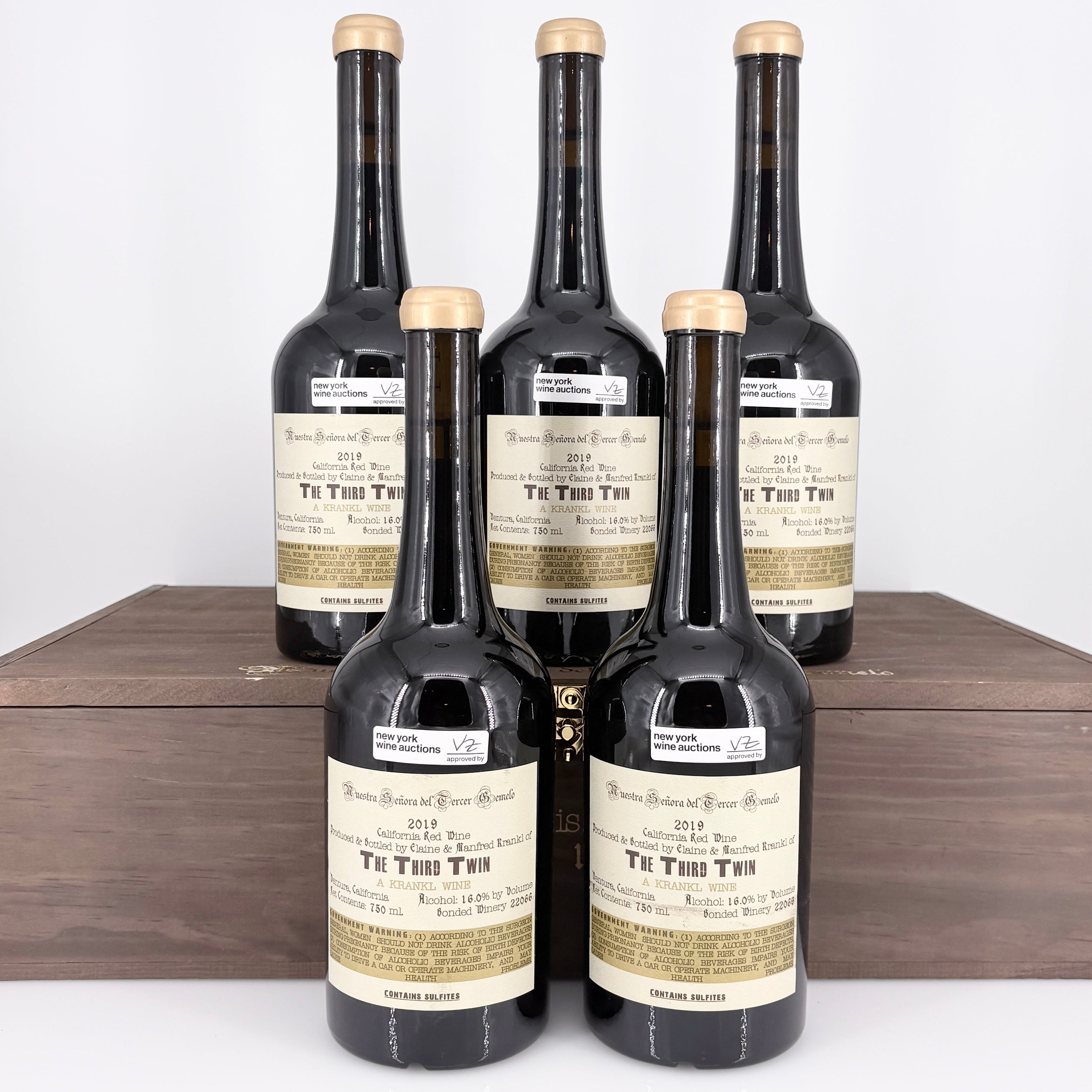 Five bottles of  wine in a wooden box on a white background