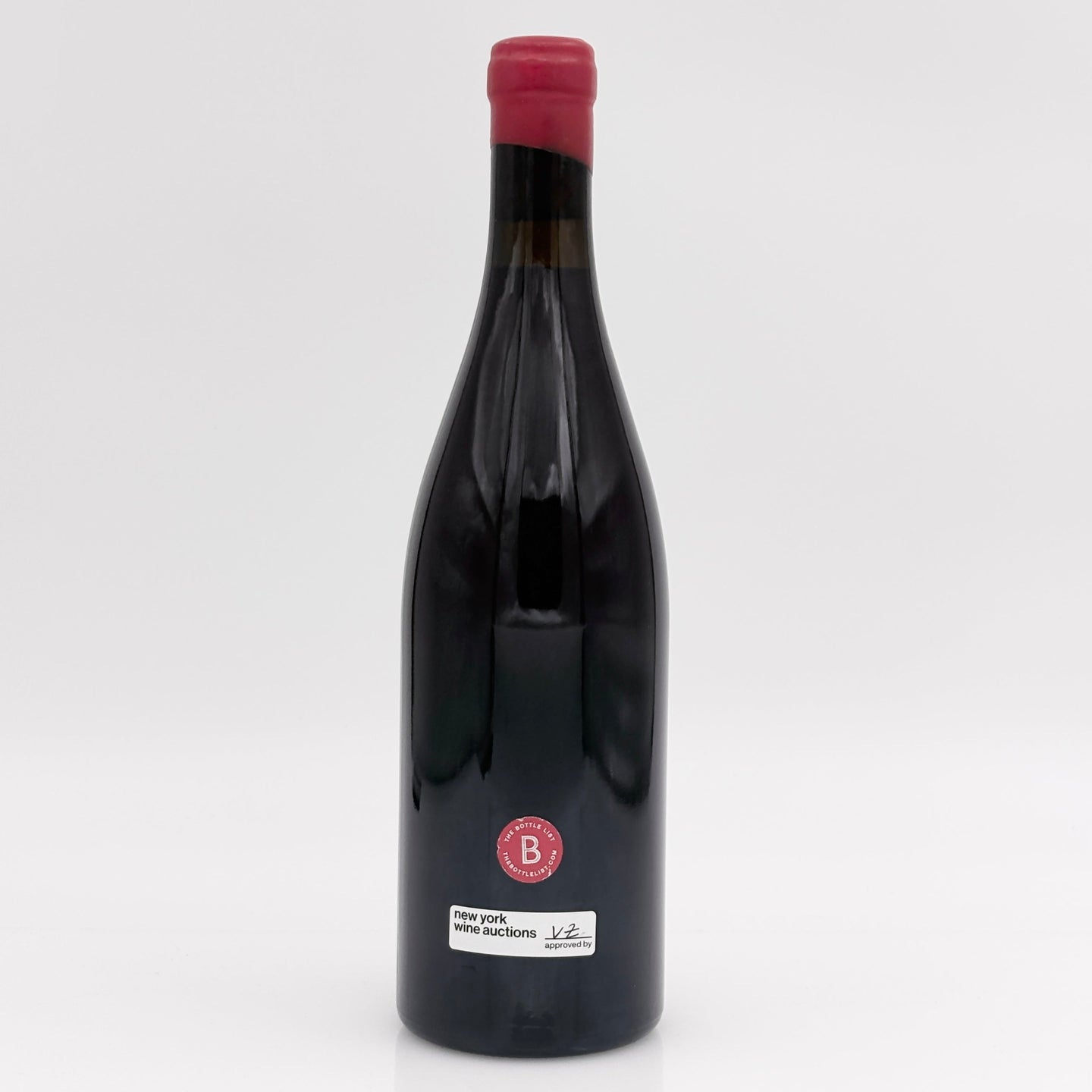 Wine bottle with a red cap on a white background