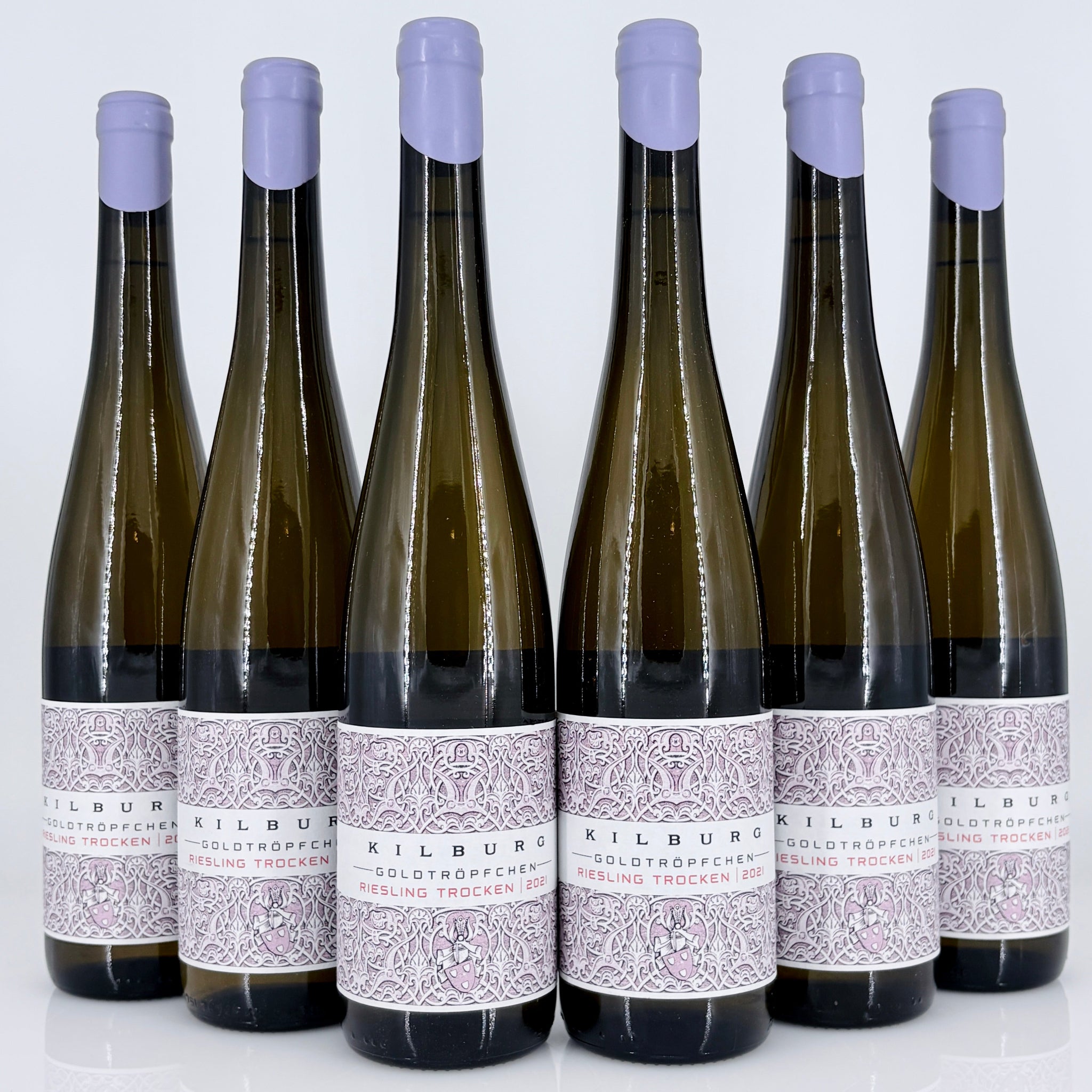 Six bottles of Kilburg Riesling Trocken wine with purple bottle caps on a white background.